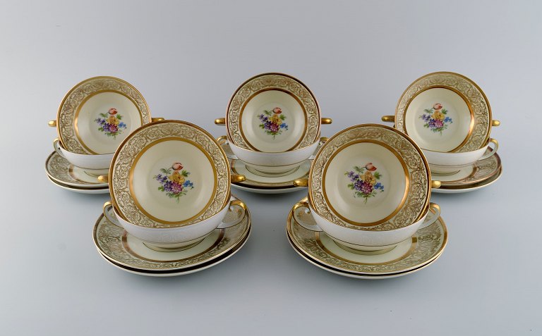 Tirschenreuth, Tyskland. 10 bouillonkopper med underkopper i porcelæn med 
blomster og gulddekoration. Midt 1900-tallet.  
