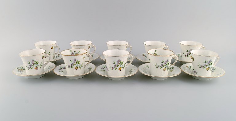 10 Rörstrand coffee cups with saucers in hand-painted porcelain. Flowers, gold 
edge and foliage in relief. Approx. 1900.
