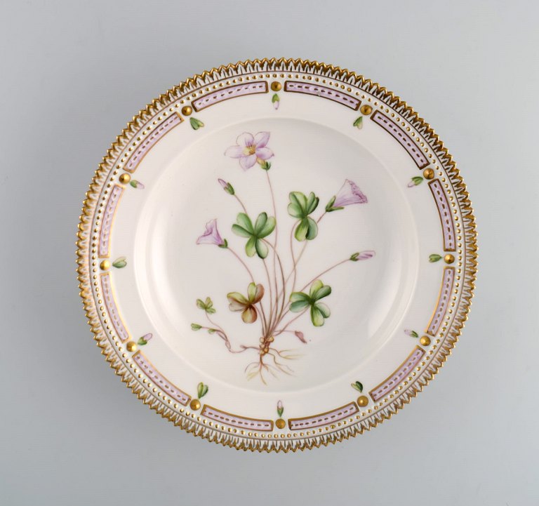 Royal Copenhagen Flora Danica dyb tallerken i håndmalet porcelæn med blomster og 
gulddekoration. 
