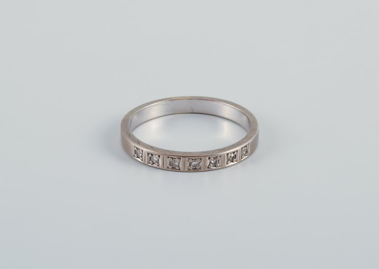 Scandinavian goldsmith. Classic alliance ring in white gold adorned with seven 
diamonds.