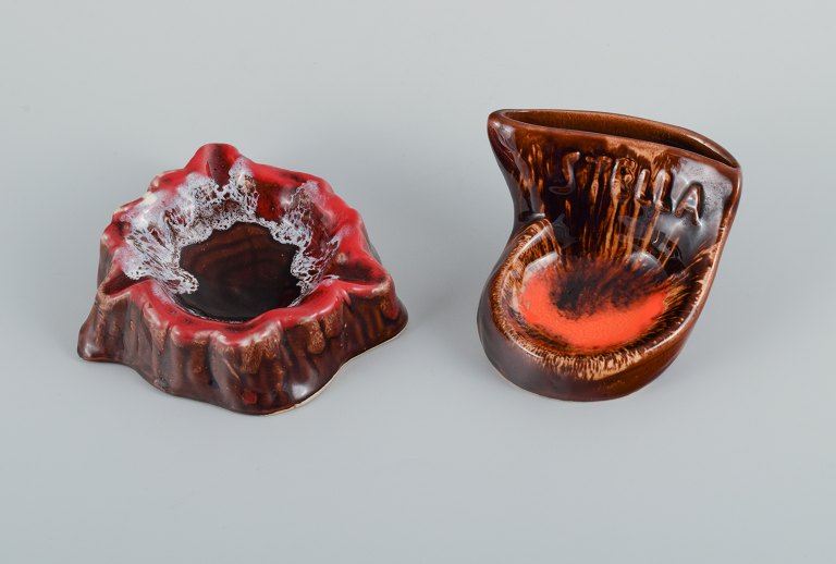 Vallauris, France, two ceramic bowls in brightly colored glazes in red and 
orange on a dark brown base.