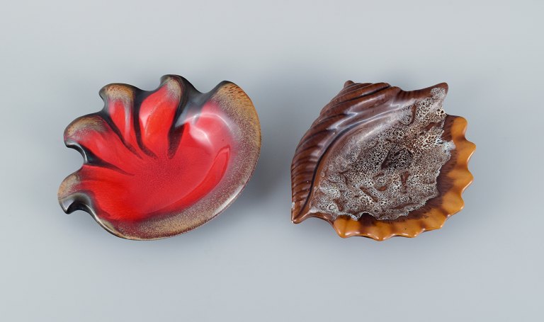 Vallauris, France, two snail-shaped bowls with glaze in shades of brown and red.