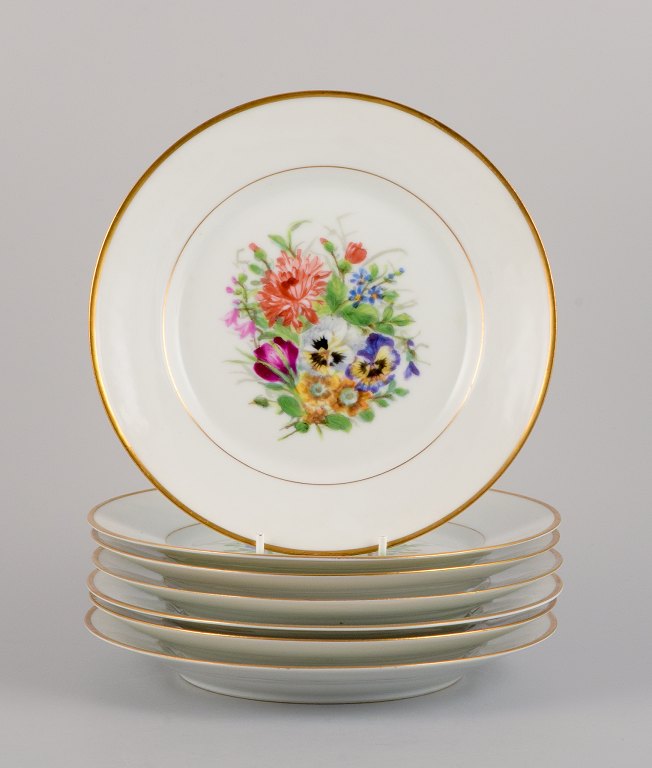 Bing & Grøndahl, syv frokosttallerkner i porcelæn håndmalet med polykrome 
blomster og gulddekoration.