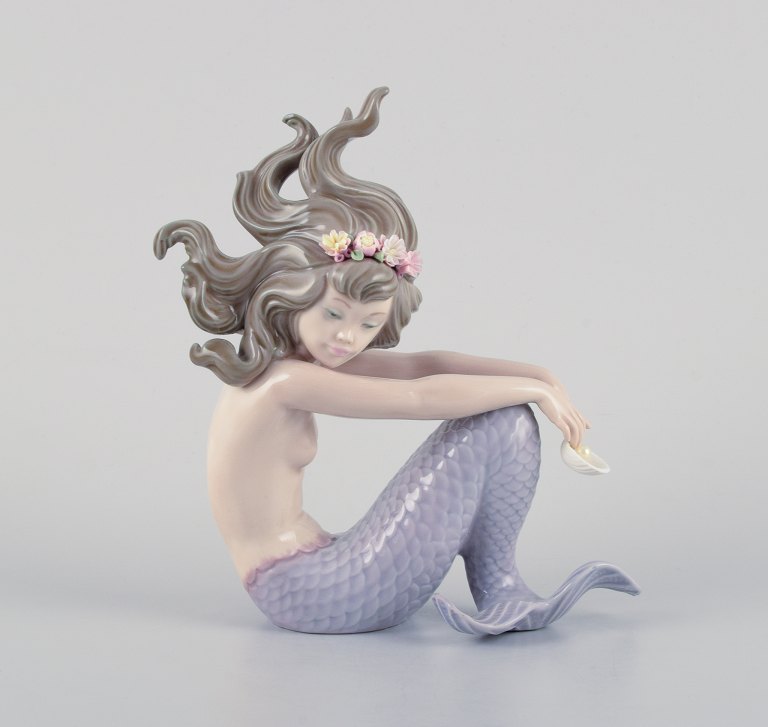 Lladro, Spain, handmade porcelain figurine of a sitting mermaid.