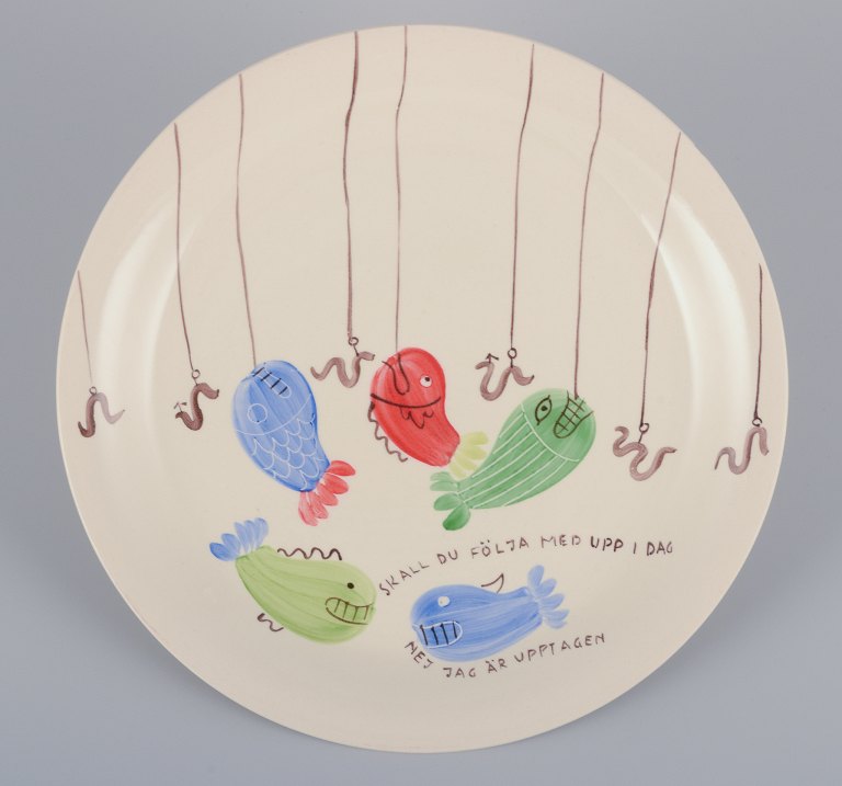 Stig Lindberg for Gustavsberg. "Löja" plate. Hand-painted with a fish motif. 
Satirical illustration with Swedish text.