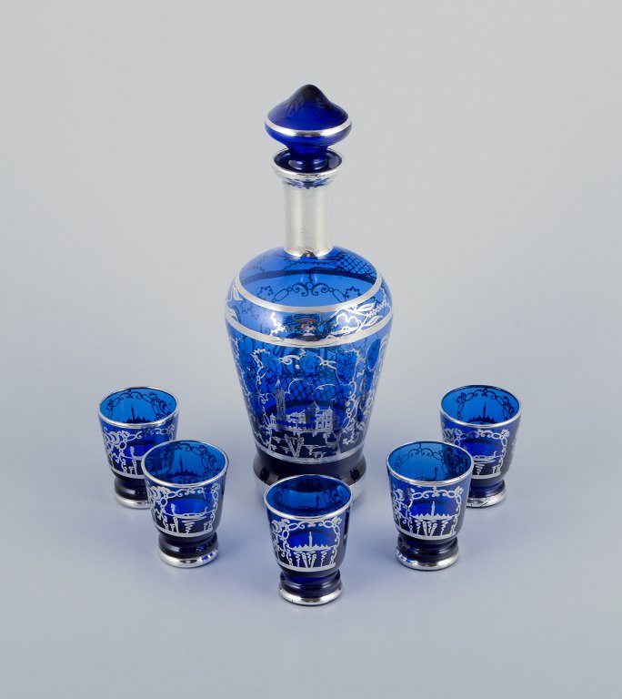 Venedig, Italien. Likørservice i blåt glas bestående af flakon og fem bægre.  
Håndmalet i sølvdekoration med Venedig motiver.