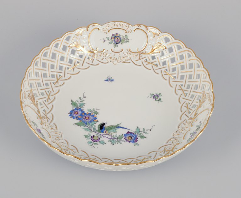 Meissen, Tyskland. Gennembrudt skål i porcelæn dekoreret i guld og med eksotisk 
fugl på blomstergren. Håndmalet.