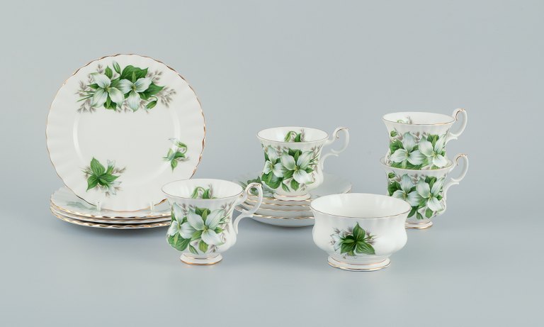 Royal Albert, England. A set of four "Trillium" coffee cups with saucers, cake 
plates, and a sugar bowl. Decorated with flowers and gold trim.