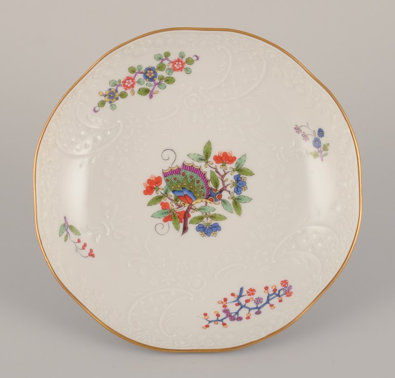 Meissen, Germany. Hand-painted dinner plate featuring a butterfly on a branch 
and polychrome flower motifs. Gold rim.