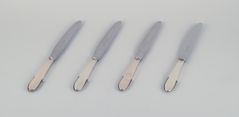 Georg Jensen, a set of four Beaded dinner knives with short handles in 830 
silver with stainless steel blades.