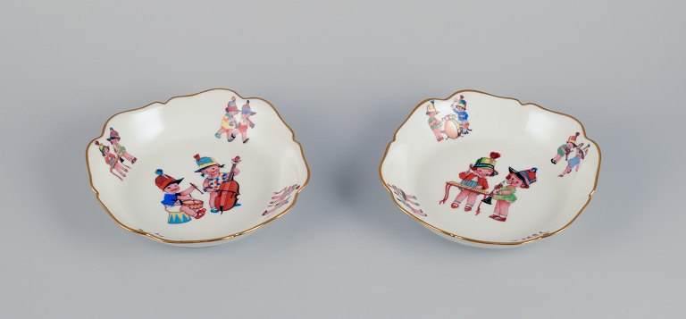 Limoges, France. Two deep childrens plates in porcelain. Gold rim. Motifs of 
child musicians.