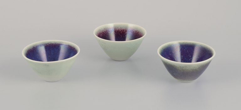 Three Rörstrand ceramic bowls with glaze in violet and green shades.