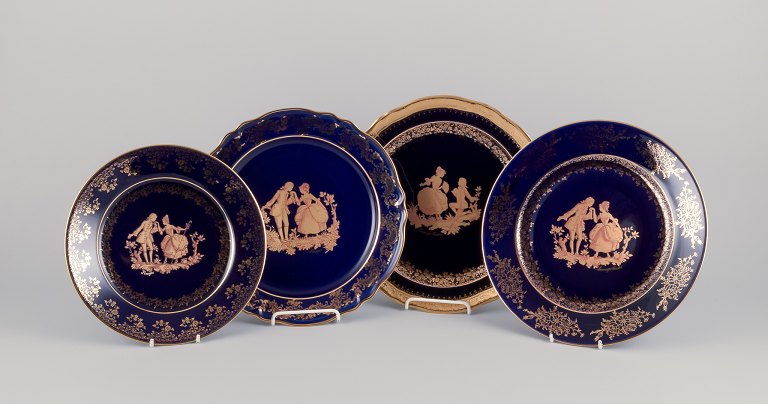 Limoges, France. Four plates in porcelain decorated with 22-karat gold leaf. 
Beautiful royal blue glaze. Scène galante.