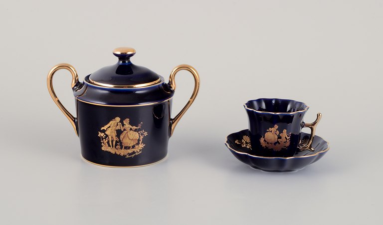 Limoges, France. Two pieces of porcelain consisting of a coffee cup and sugar 
bowl decorated with 22-karat gold leaf and beautiful royal blue glaze.