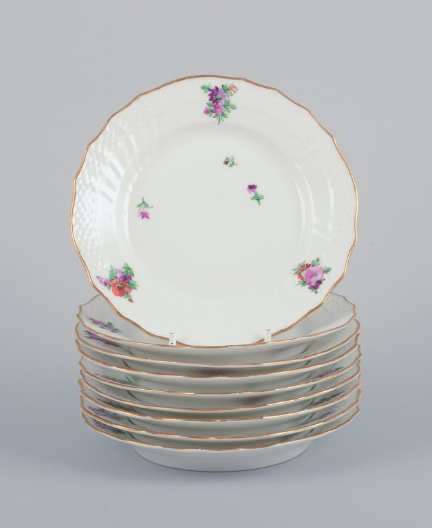 Royal Copenhagen Saxon Flower. Nine porcelain plates. Hand-painted with 
polychrome flowers. Gold rim.